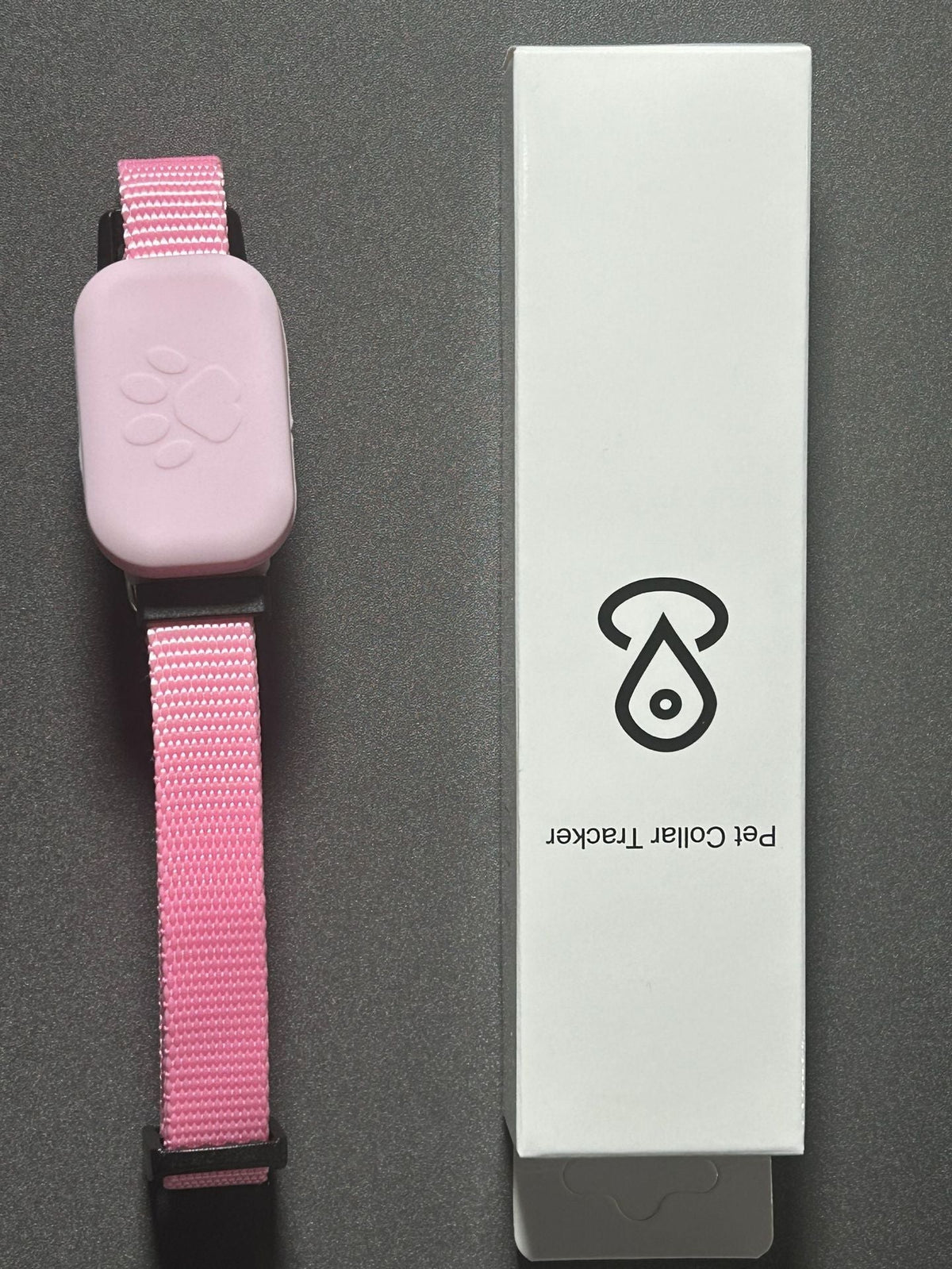 Rosa TrackTag™ Tracking-Halsband mit Pfotenmotiv neben der Produktverpackung